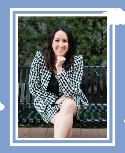 Photo of powerful latina woman sitting on a park bench in a black and white houndstooth suit